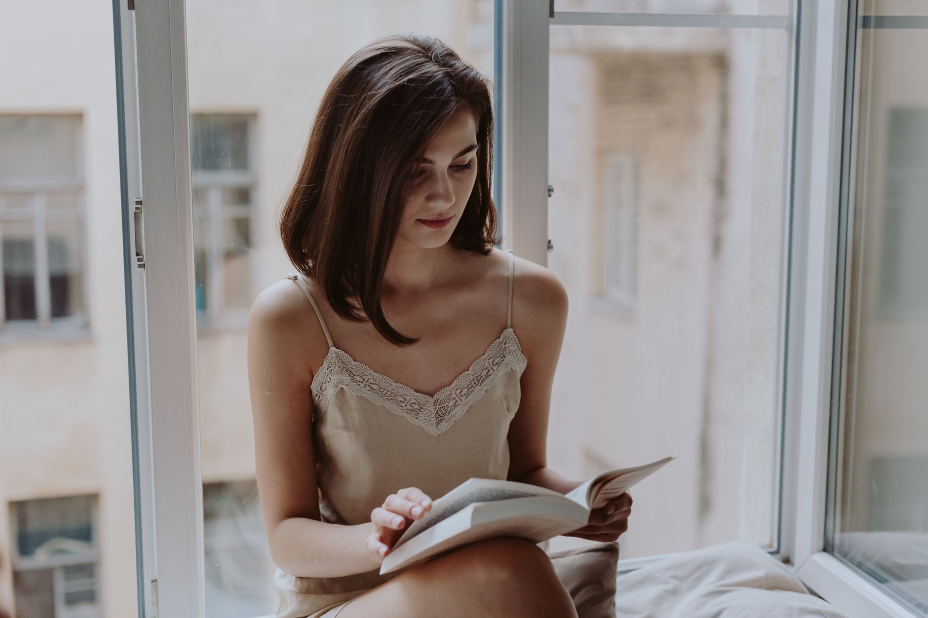Personne lisant un livre près d'une fenêtre lumineuse — Photo: cottonbro studio